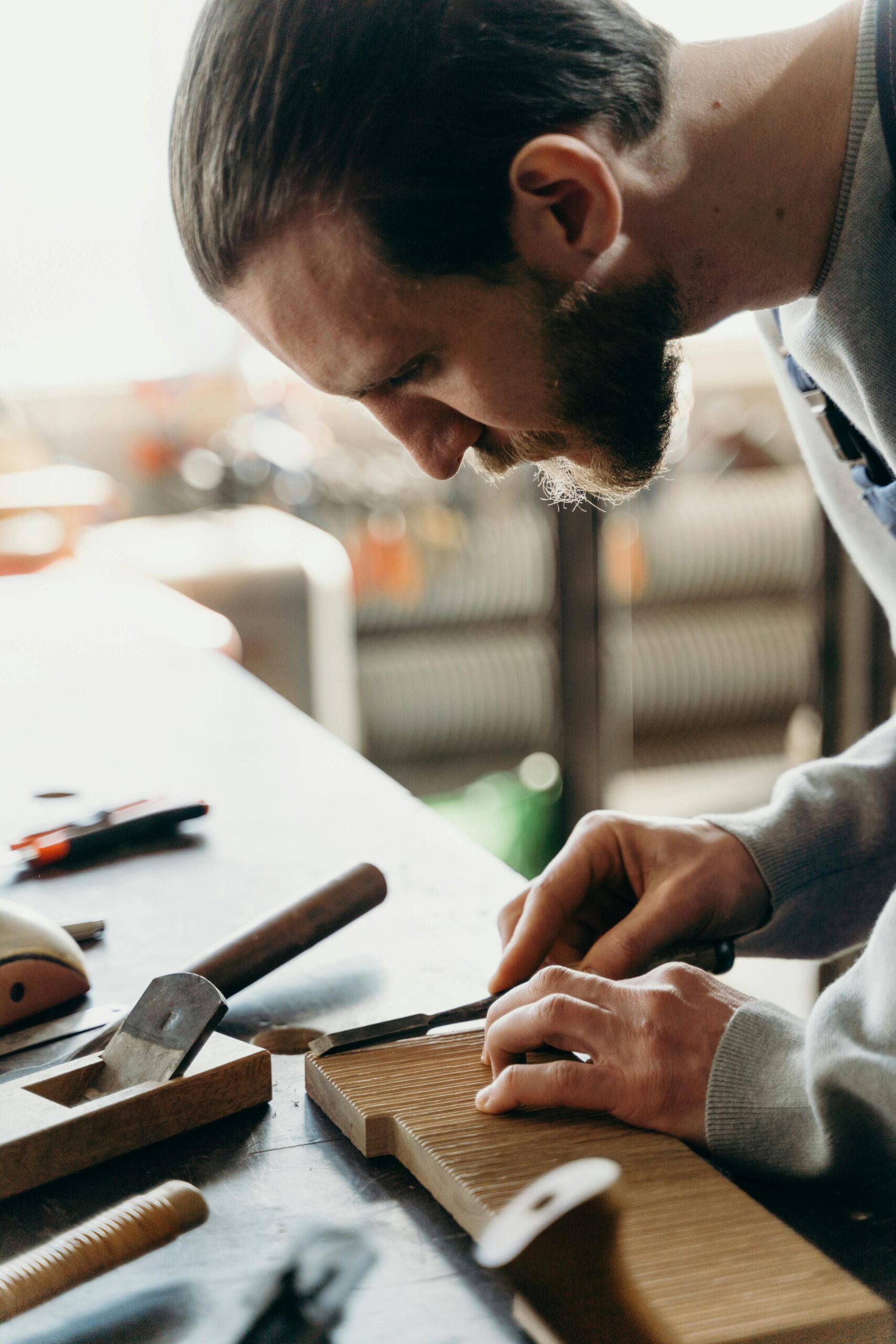 A skilled carpenter shaping wood with precision tools in a well-lit workshop.
